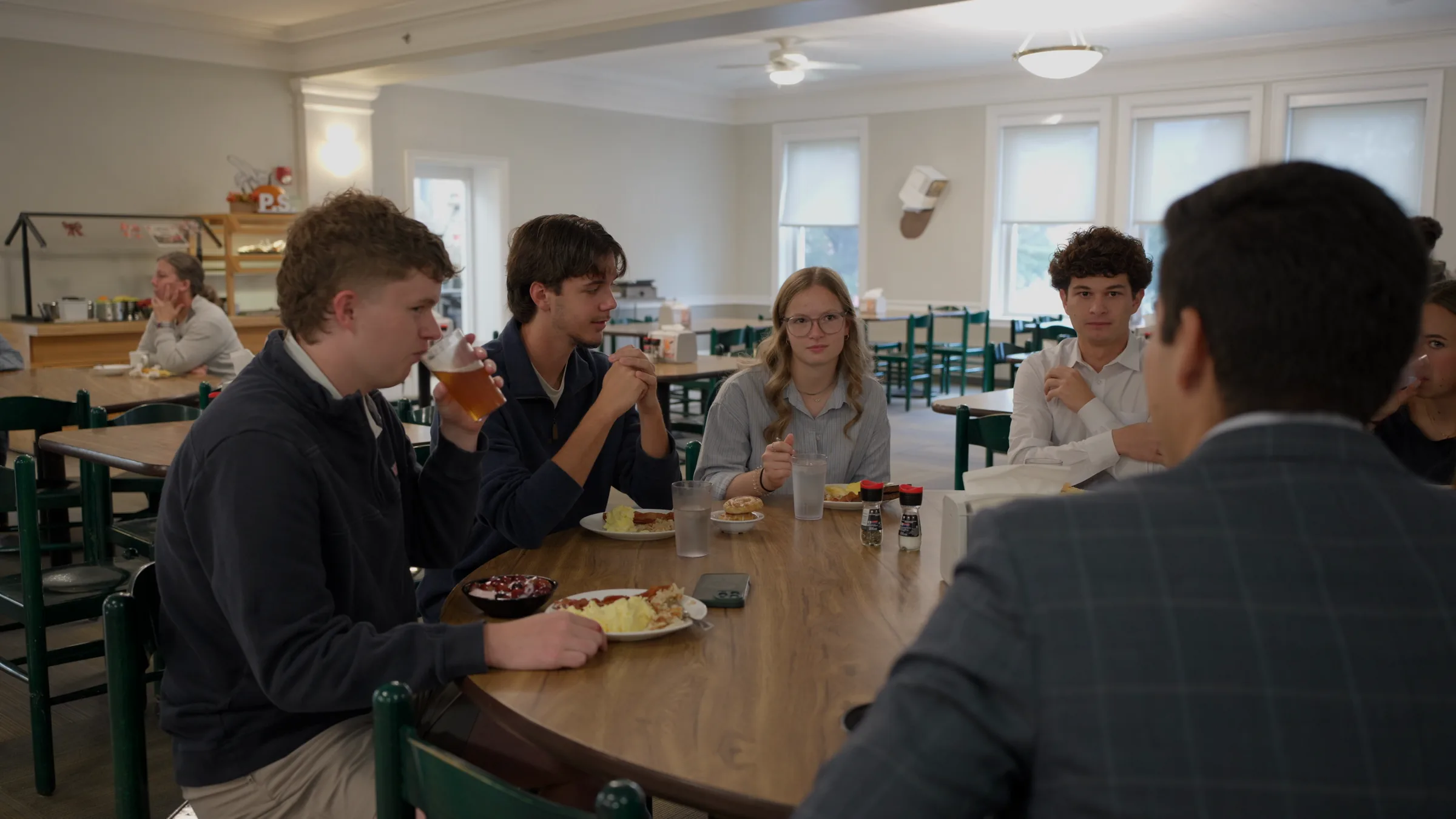 Rodrigo García de la Vega, de espaldas, come con alumnos en una mesa del comedor de Hebron Academy