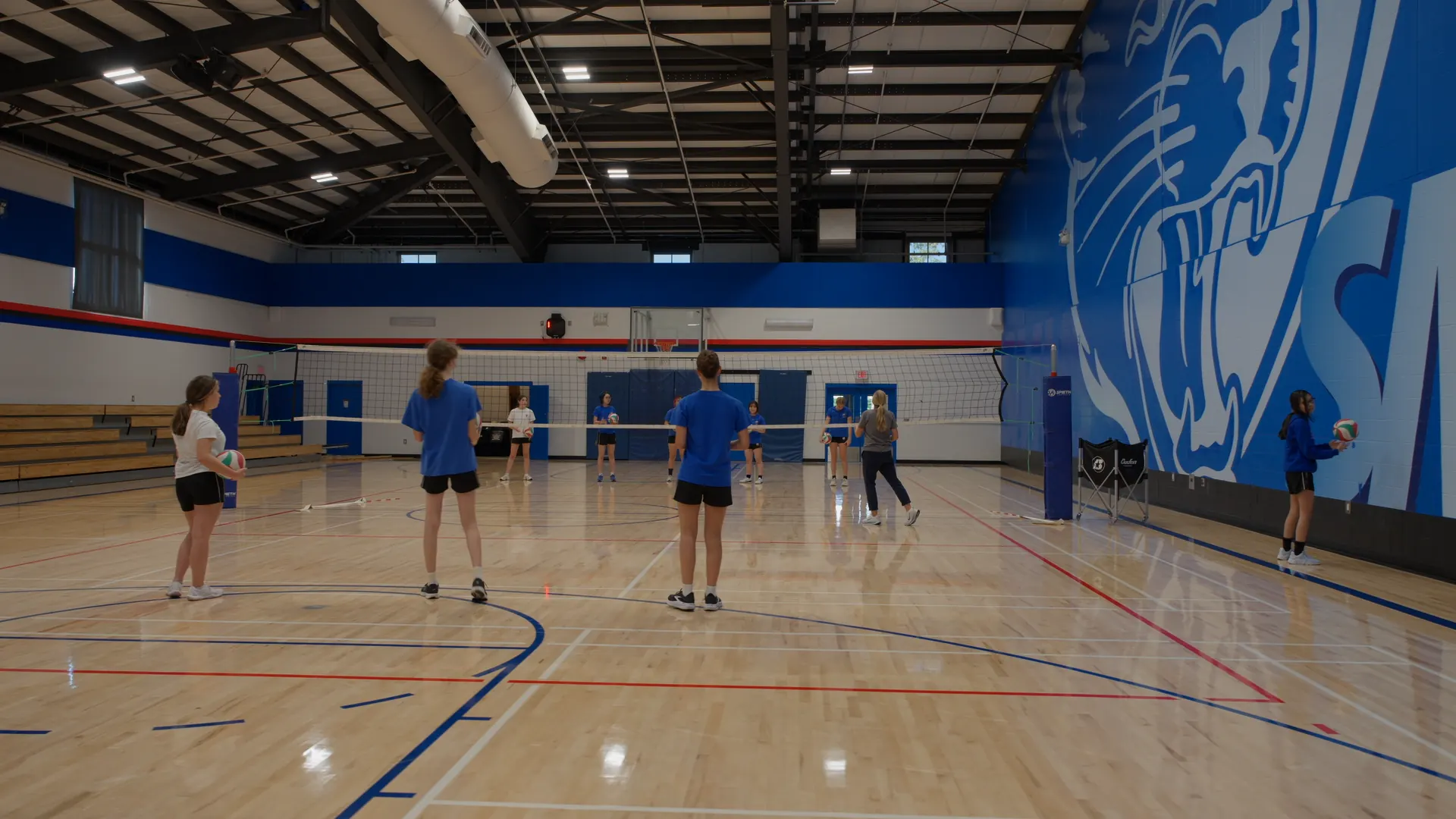 Alumnas de St. Michaels University School entrenando voleibol en el gimnasio de la escuela
